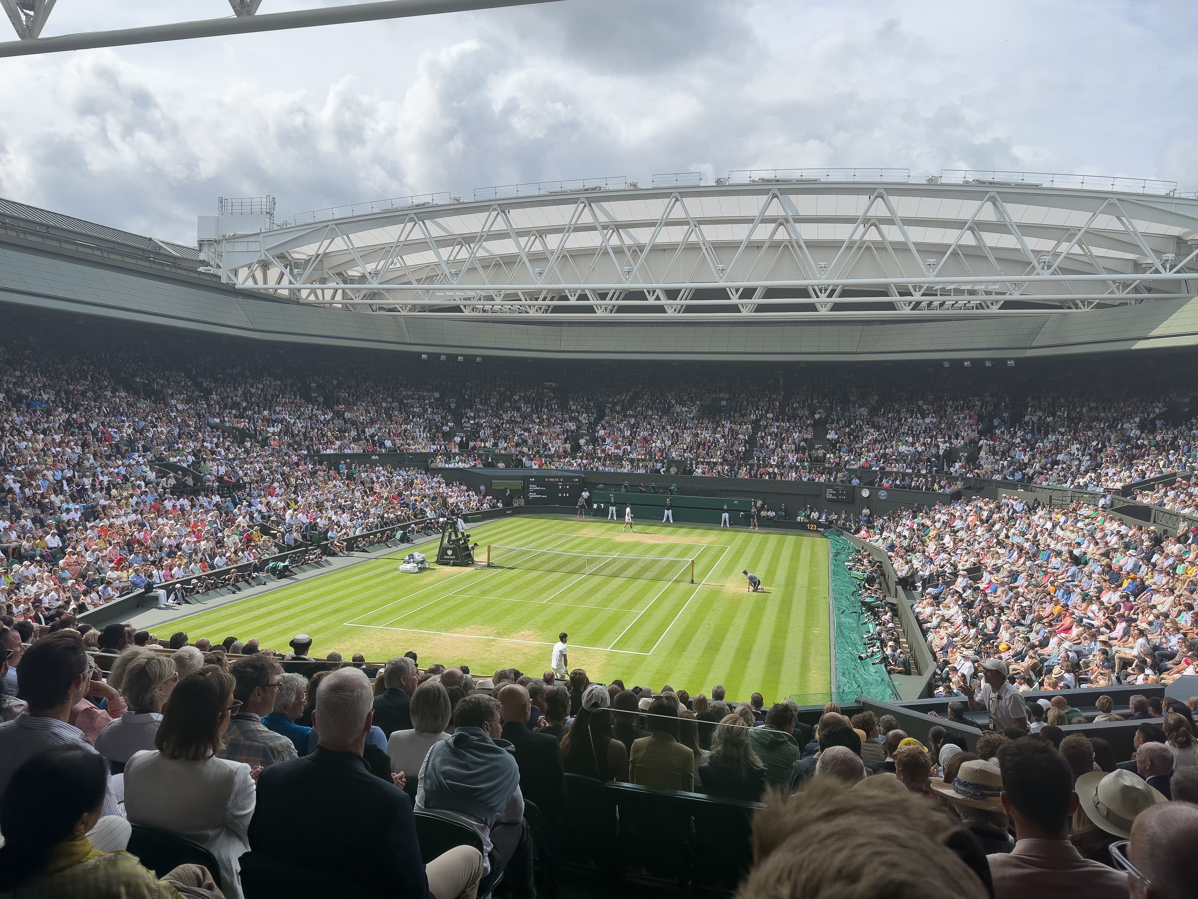 Centre Court at the All England Lawn Tennis Club during the 2022 Wimbledon Championships, showing the grass court and packed stands