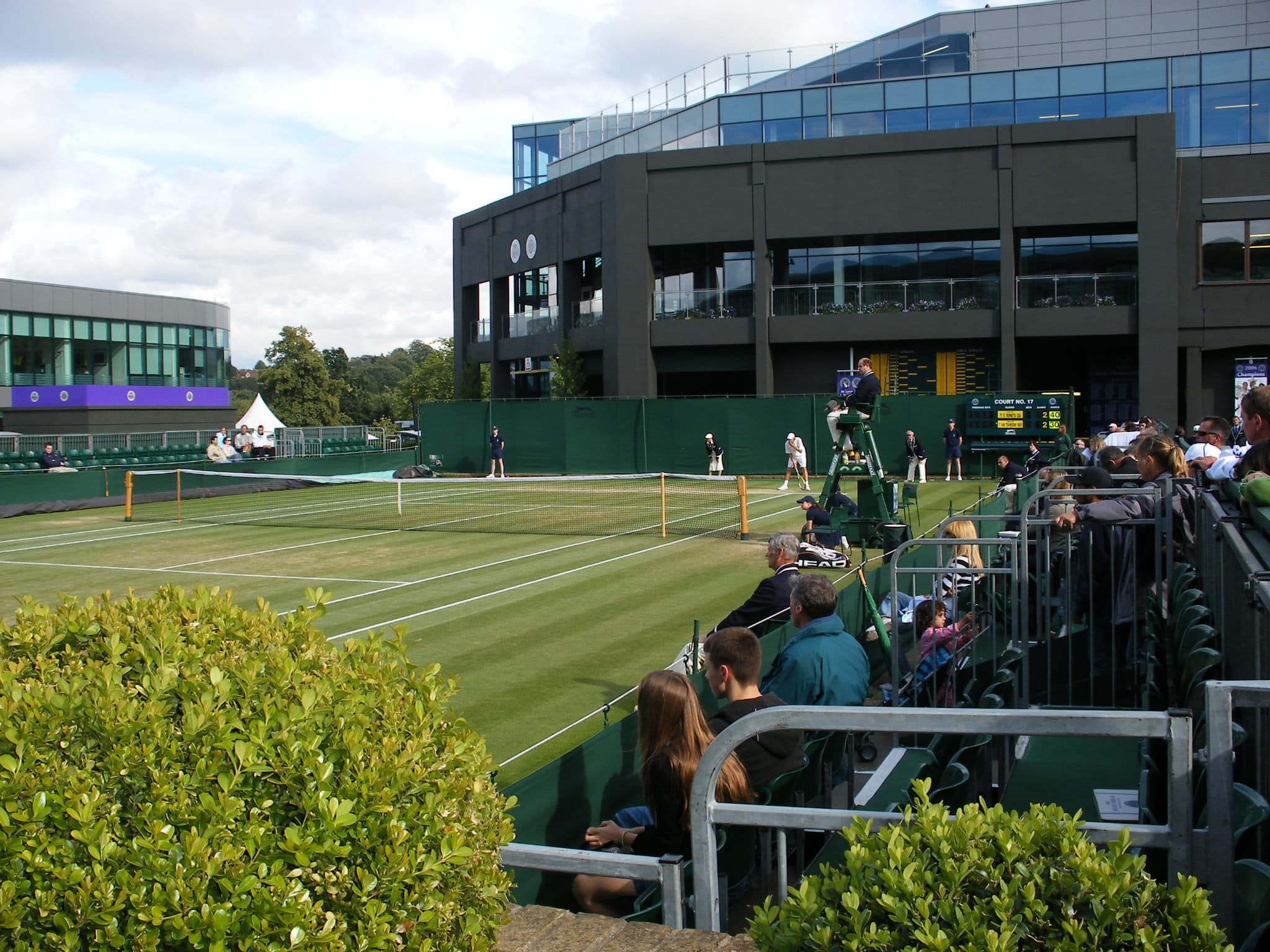Spectators watching a match on Court 17 at Wimbledon from the small outer court stands
